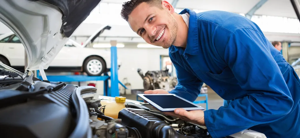A technician working on a Ford in a service bay