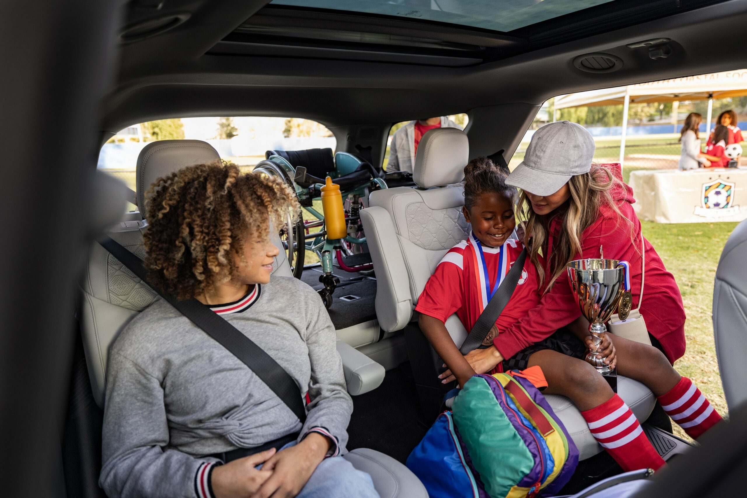 Children and an adult in the second row of a 2027 Ford Explorer after a game