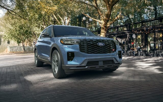 A light blue 2027 Ford Explorer on a brick street under mature trees