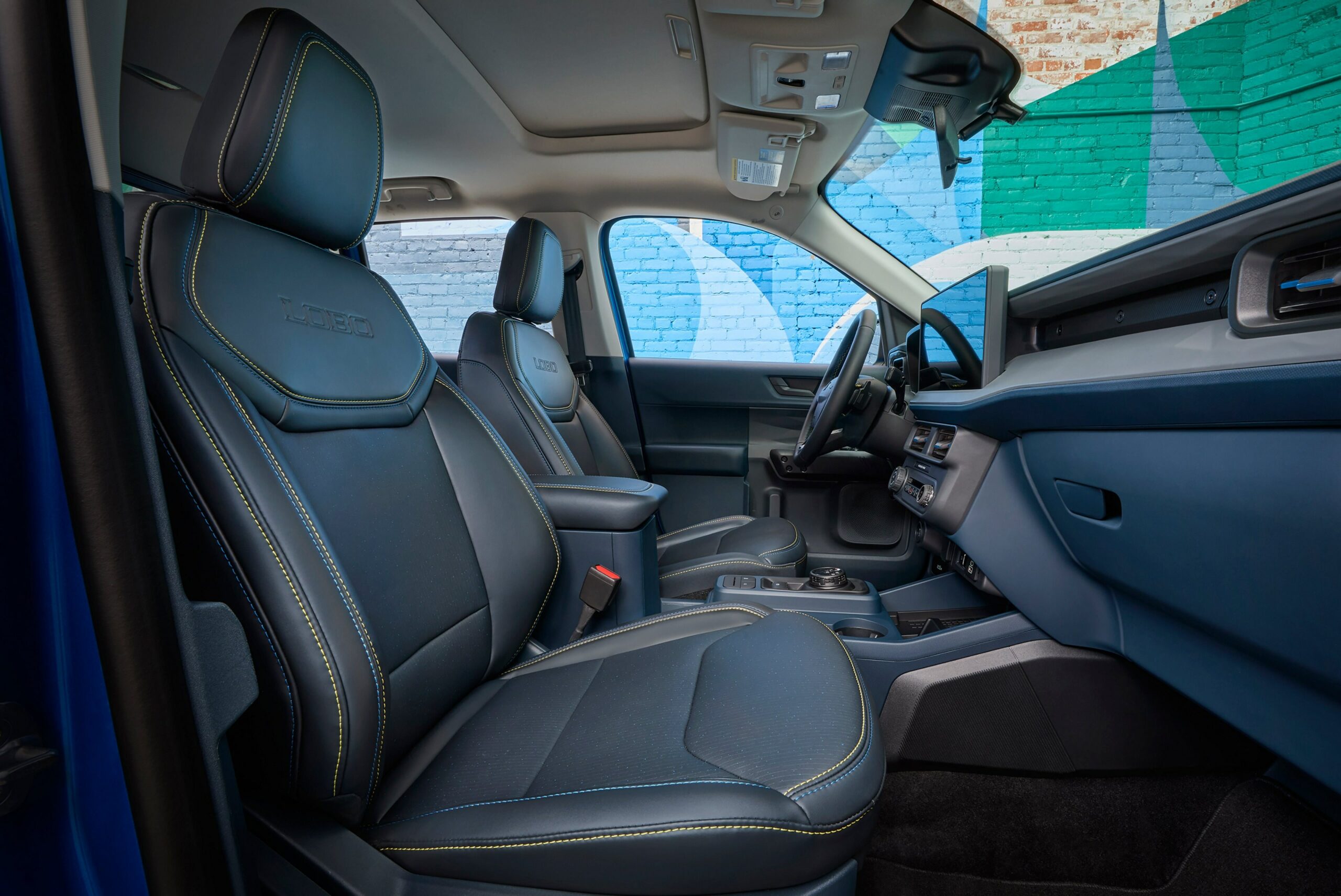 The front seats of a 2026 Ford Maverick Lobo in black with yellow contrast stitching
