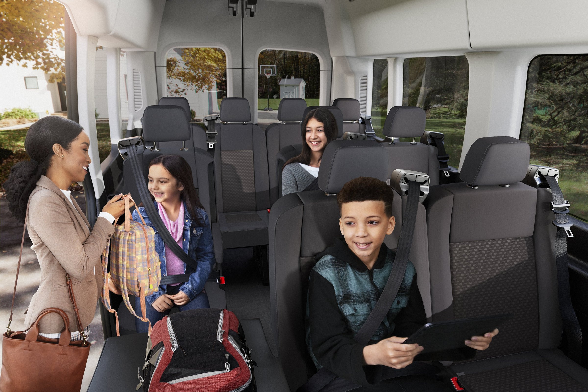A mother and three children seated in the rear rows of a Ford Transit Passenger Van, all belted in, with daylight through the side windows