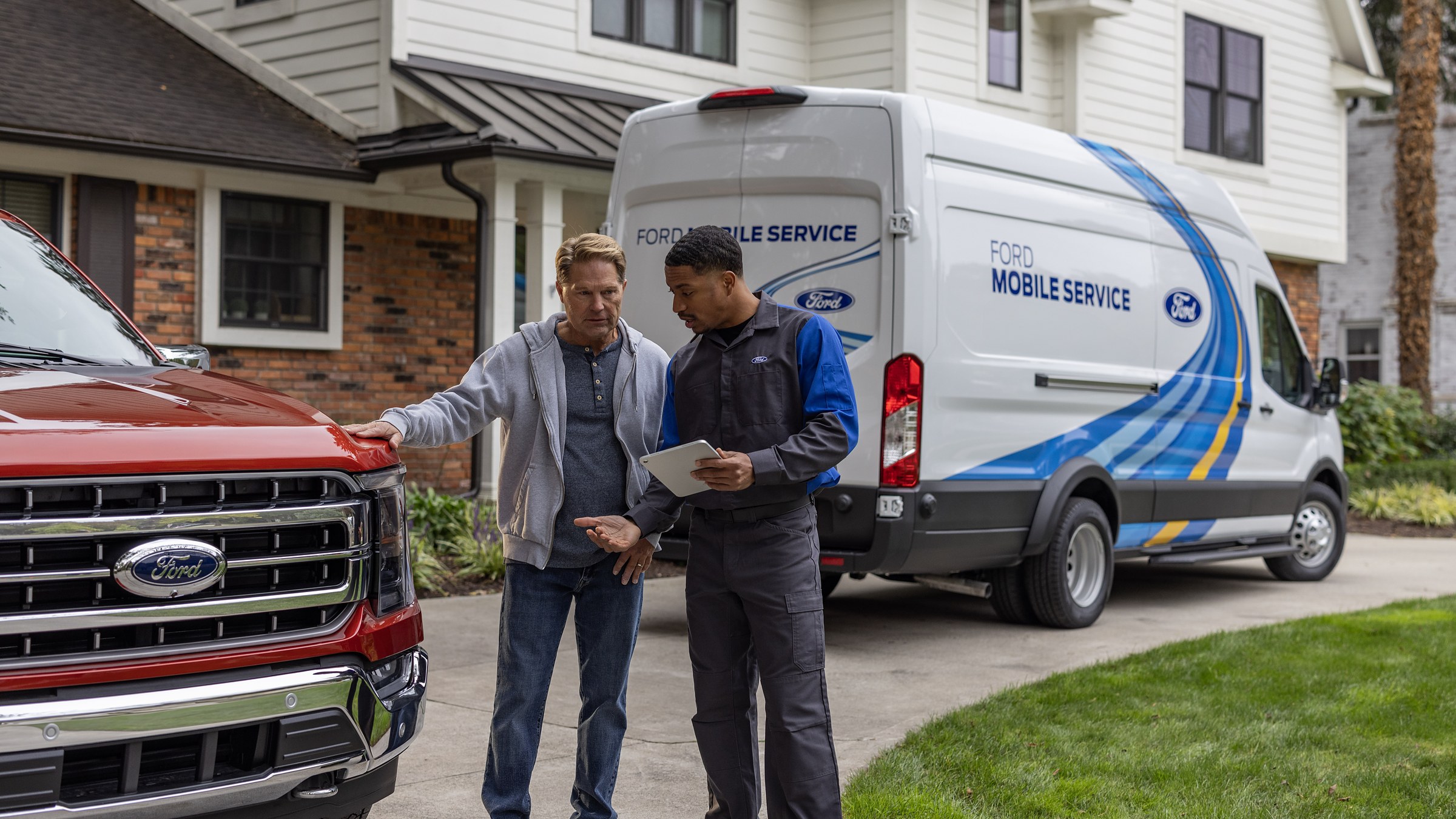 A Ford Mobile Service van parked on a driveway while a technician talks with a customer