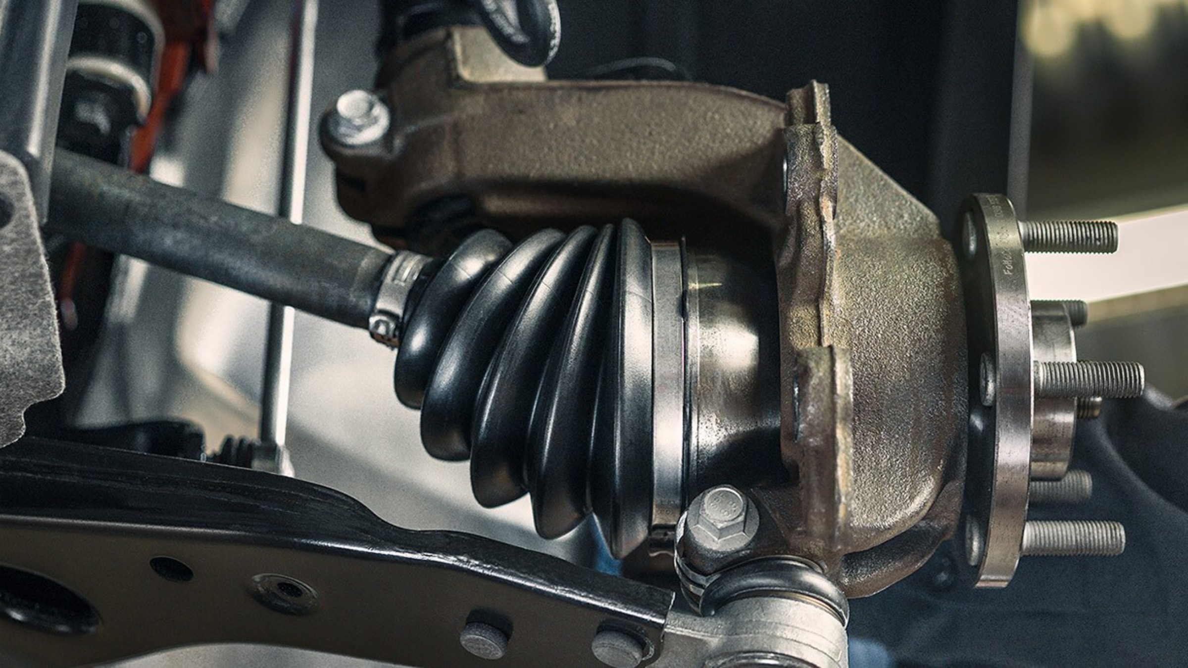 A Ford front hub, CV joint boot and lower control arm seen from under a vehicle