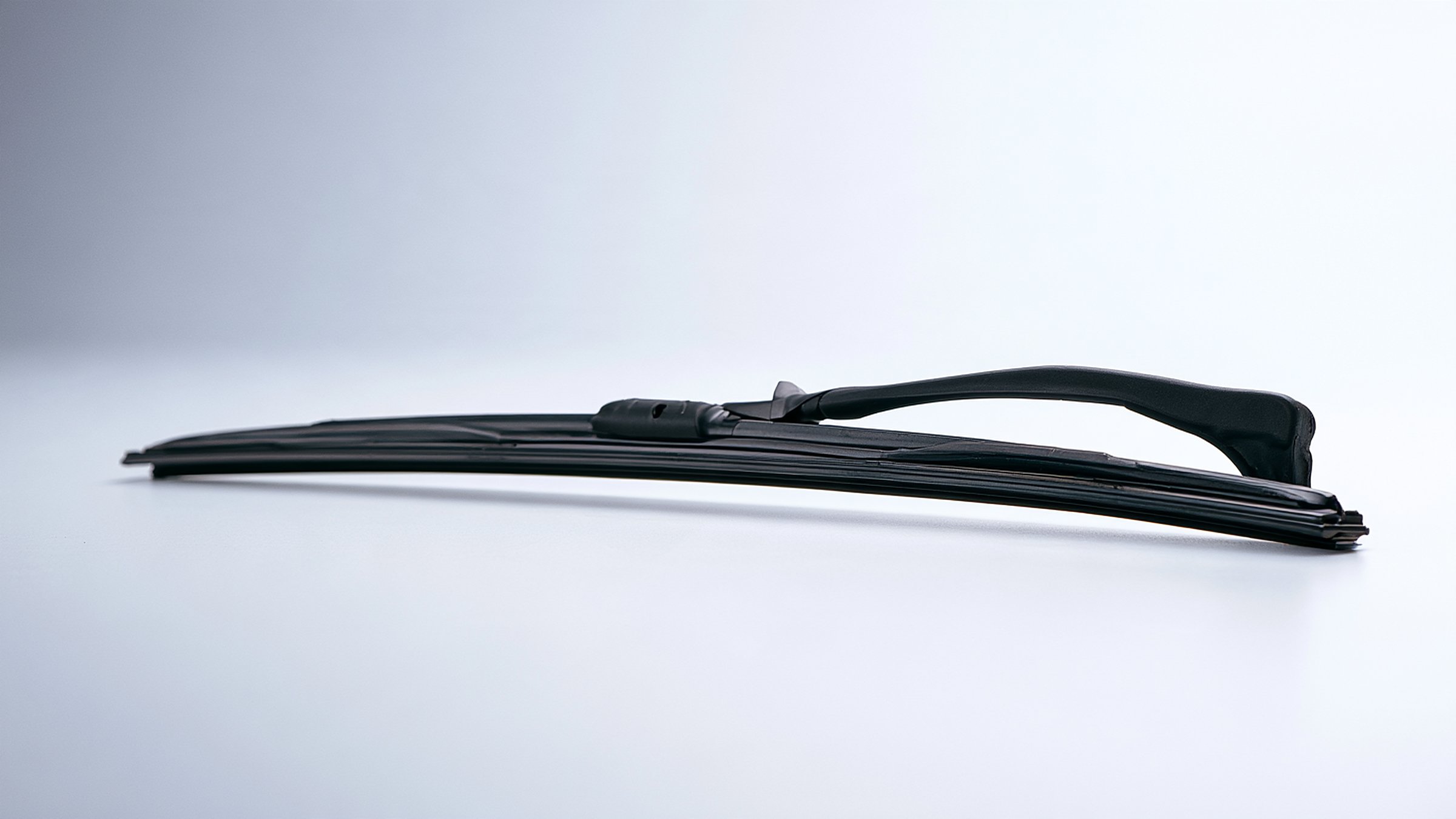 A new windshield wiper blade on a bright, pale surface