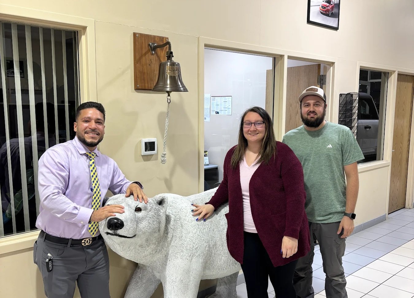 Three members of the Huntley Ford team beside the dealership’s polar bear mascot.